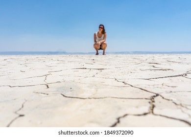 Alvord, Oregon, USA - June 23rd 2018: Cracked earth in the Alvord Desert with in the background a woman. Close up on the cracked earth
