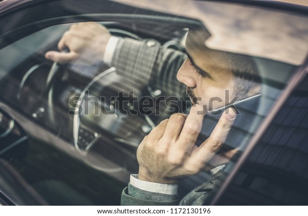 Always be in contact. Business man\
sitting in car and talking on mobile phone. Close\
up.