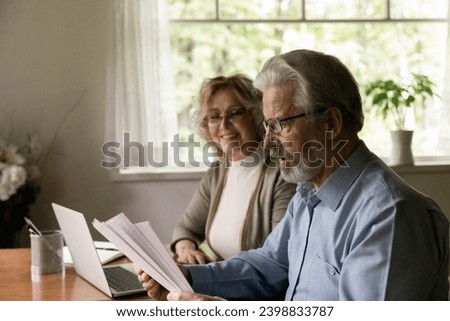 I always believed in you, dear. Happy smiling aged female wife watching surprised senior male husband reading paper letter with lucrative deal proposal good business news profitable financial report