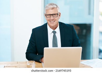 I Always Get My Work Done. Cropped Portrait Of A Handsome Mature Businessman Working On His Laptop In The Office.