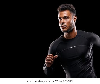Always give 100 percent. Studio shot of a handsome young man running against a black background. - Shutterstock ID 2136774681