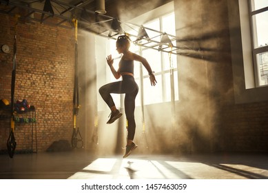 Always in good shape Full length of athletic woman in black sport clothing exercising in professional gym.