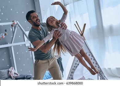 Always happy together. Full length of father carrying his daughter and smiling while spending free time at home - Shutterstock ID 639868000