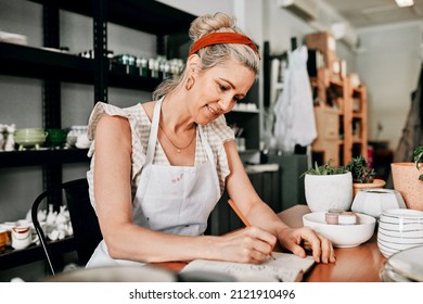 I Always Sketch My Ideas. Cropped Shot Of An Attractive Mature Woman Sitting Alone In Her Pottery Workshop And Sketching In A Notebook.