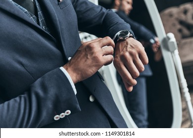 Always In Time. Close Up Of Young Man In Full Suit Checking The Time While Standing In Front Of The Mirror Indoors          