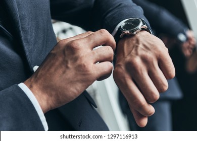 Always In Time. Close Up Of Young Man In Full Suit Checking The Time While Standing In Front Of The Mirror Indoors