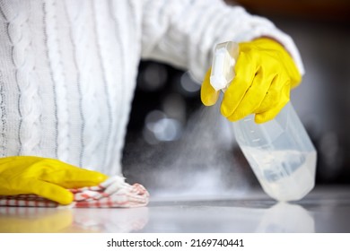 Always Use A Strong Disinfectant. Shot Of A Woman Spraying Her Kitchen Counter To Clean It.