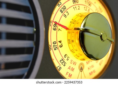 AM, FM, SW frequency bands lighted up when turned on with dial to manually tune in to stations and channels and listen to broadcast of music, news and other programs over the airwaves. Closeup view. - Shutterstock ID 2259437353