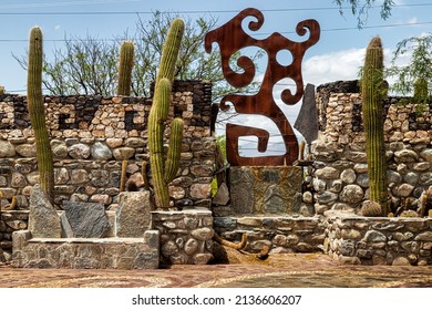 Amaicha del Valle, Tucuman, Argentina - January 12, 2021: Iron sculpture with cactus on stone wall in the Pachamama Museum