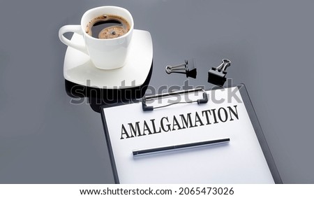 AMALGAMATION text on paper sheet with coffee on black background