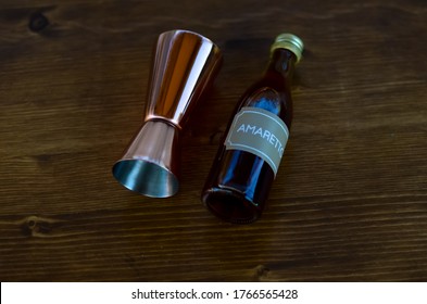 Amaretto Bottle With Jigger On The Wood