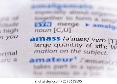 Amass word in a dictionary. Selective focus, close up.