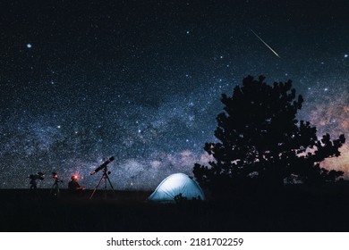 Amateur astronomer with astronomical telescope camping in nature under the Milky way stars.