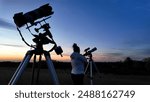 Amateur astronomer looking at the evening skies, observing planets, stars, Moon and other celestial objects with a telescope and camera on a star tracker.