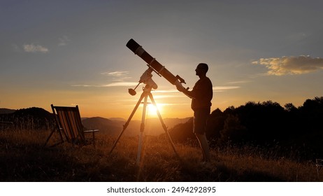 Amateur astronomer looking at the evening skies, observing planets, stars, Moon and other celestial objects with a telescope just before sun down. - Powered by Shutterstock