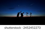 Amateur astronomers looking at the evening skies, observing planets, stars, Moon and other celestial objects with a telescope and camera on a star tracker.