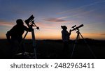 Amateur astronomers looking at the evening skies, observing planets, stars, Moon and other celestial objects with a telescope and camera on a star tracker.