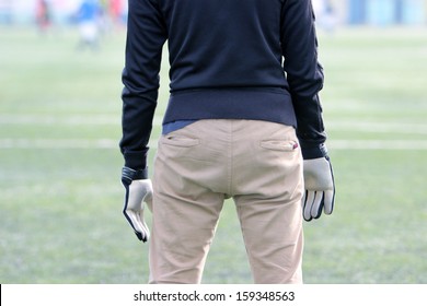 Amateur Goalkeeper On The Field In Jeans And Gloves