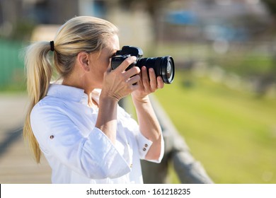 photographe amateur d'âge moyen prenant des photos à l'extérieur