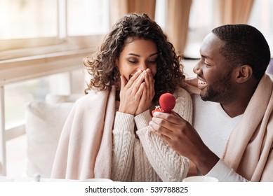 Amazed African American couple getting engaged in the cafe - Powered by Shutterstock