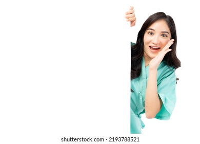 Amazed asian woman hiding behind white wall with blank space isolated on white background Patient girl peeping out a side of white Advertising Board For Text Design or Advertisement Smiling Lady shout