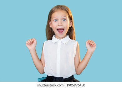 Amazed Child. Perfect Result. Wow Reaction. Portrait Of Surprised Astonished Excited Sweet Little Girl In Formal Outfit Celebrating Success Isolated On Blue Copy Space Background.