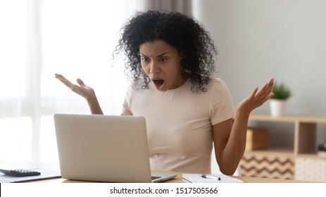Amazed confused frown african woman open mouth gawp look at computer screen, 30s female received shocking news, having big serious problems unsaved document, critical error, need repair master concept - Shutterstock ID 1517505566