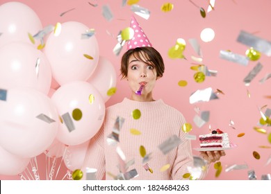 Amazed Fun Young Woman In Casual Sweater Hat Celebrating With Falling Confetti Hold Air Balloons Cake Blowing In Pipe Isolated On Pastel Pink Background. Birthday Holiday Party People Emotions Concept