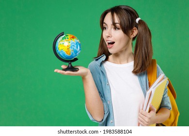 Amazed Funny Young Woman Student In Basic Blue Shirt Backpack Hold Notebooks Earth World Globe Isolated On Green Color Background Studio Portrait. Education In High School University College Concept