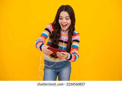 Amazed girl 12, 13, 14 years old with smart phone. Hipster teen girl types text message on cellphone, enjoys mobile app. Kid hold smartphone texting in online social media. Excited teen girl.