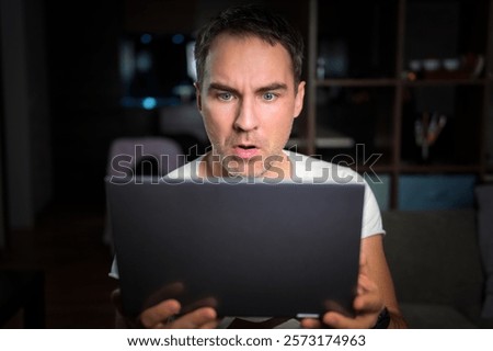 Amazed happy guy using digital tablet looking shocked about social media news, astonished man shopper consumer surprised excited by online win isolated on pink studio background.