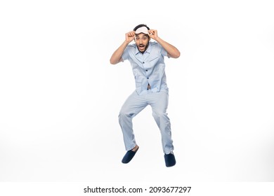 Amazed Man In Pajamas And Sleeping Mask Levitating On White