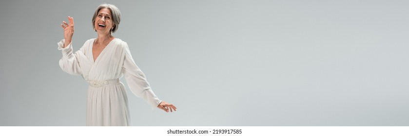 Amazed Middle Aged Bride In White Wedding Dress Gesturing Isolated On Grey, Banner