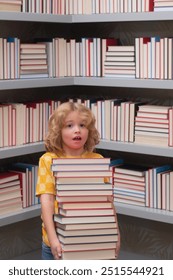 Amazed school kid hold stack of books. Nerd pupil. Back to school. School kid pupil studying in school library. Child reading book in library on bookshelf background.