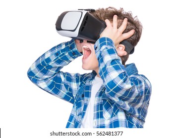 Amazed Teen Boy Wearing Virtual Reality Goggles Watching Movies Or Playing Video Games, On White. Surprised Teenager Looking In VR Glasses. Emotional Portrait Of Child Experiencing 3D Gadget