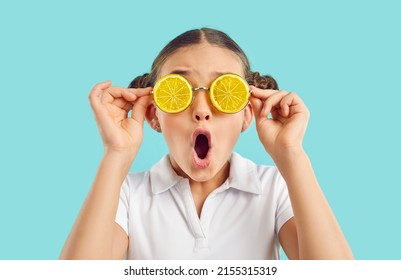 Amazed teen girl child isolated on blue studio background in funny glasses with oranges feel shocked by summer deal or offer. Stunned small kid wear cool eyewear. Seasonal sale concept. - Shutterstock ID 2155315319