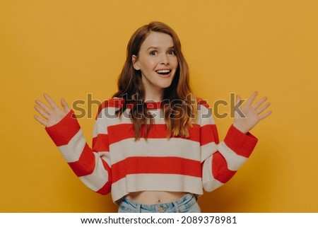 Amazed teen girl raising palms with excitement while standing isolated over yellow background, happy female can not believe her eyes, shocked female losing speech from amazement, being surprised Stock photo © 