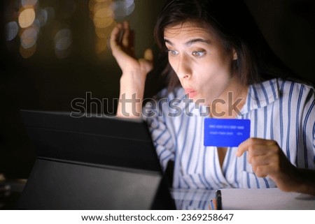 Amazed woman buying with tablet and credit card in the night at home