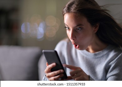 Amazed Woman Checking Smarrt Phone Speed Connection Sitting On A Couch In The Night At Home