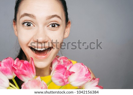 the amazed woman holding a bouquet of flowers in her hands, on March 8