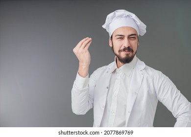 Amazed young male Italian handsome chef. He is Gesturing delicious sign, studio shot includes copy space.