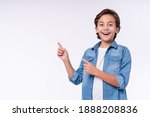 Amazed young male kid pointing at copy space isolated over white background