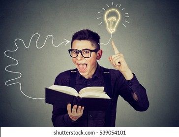 Amazed young man in glasses reading book comes up with an idea - Shutterstock ID 539054101