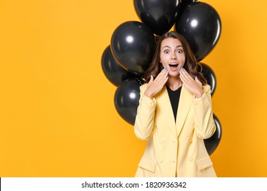 Amazed young woman in suit jacket celebrating birthday holiday party with bunch of air ballons keeping mouth open put hands on cheeks isolated on yellow background studio portrait. Black friday sale - Shutterstock ID 1820936342