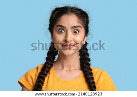Amazement Concept. Portrait Of Emotional Young Arab Woman Looking At Camera With Excitement, Closeup Shot Of Surprised Middle Eastern Female Posing Isolated On Blue Background, Free Space