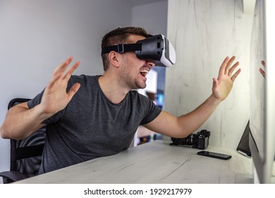 Amazing 3D stimulation, VR glasses. Young man wears virtual reality goggles and tests technology possibilities in a closed office and at home Futuristic approach model of work in the creative industry - Powered by Shutterstock