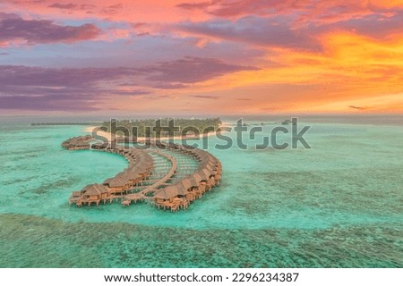 Amazing aerial beach landscape. Beautiful Maldives sunset seascape view. Horizon colorful sea sky clouds over water villa pier pathway. Tranquil drone view island lagoon tourism travel exotic vacation