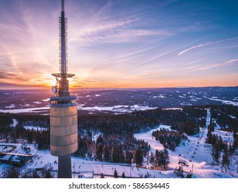 Amazing aerial drone shot of TV Tower Tryvannstårnet at winter evening at sunset