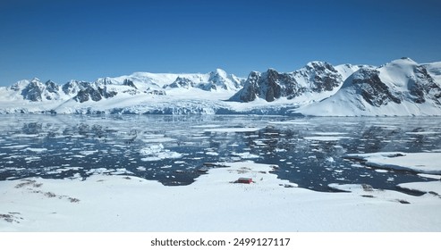 Amazing Antarctica winter landscape. Snow covered mountains towering polar ocean under bright blue sky. Ice floes icebergs melting in sunny day. Ecology, climate change, global warming. Aerial shot - Powered by Shutterstock