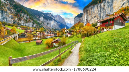 Amazing autumn landscape of touristic alpine village Lauterbrunnen with famous church and Staubbach waterfall. Location: Lauterbrunnen village, Berner Oberland, Switzerland, Europe.